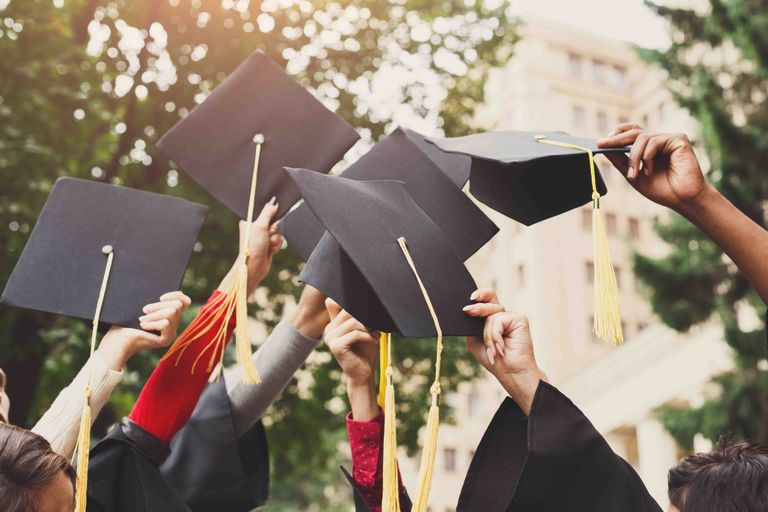 A group of students celebrating their graduation by throwing caps in the air