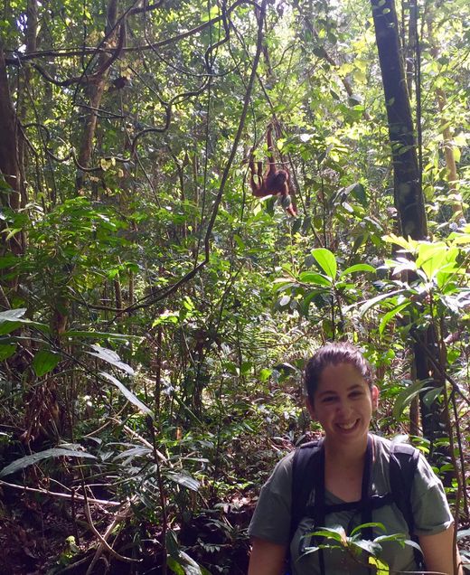 Zoe Albert in the rainforest with an orangutan