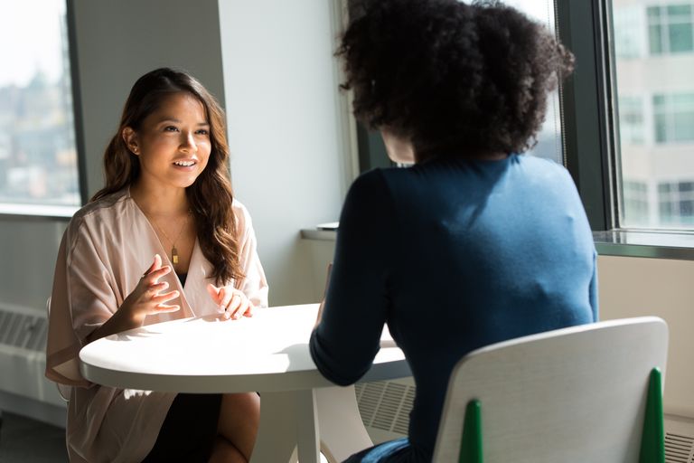 Student and advisor sitting across from each other talking at a table