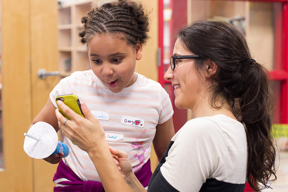 Angela Rigden and Cassandra Riley watching a video of the inside of the kaleidoscope Riley constructed for a Girls Science Club project.