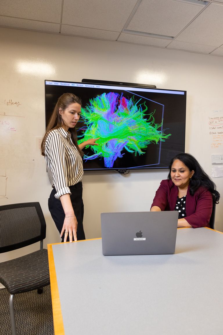 Photo of Swathi Kiran and Anne Billot reviewing brain scans.