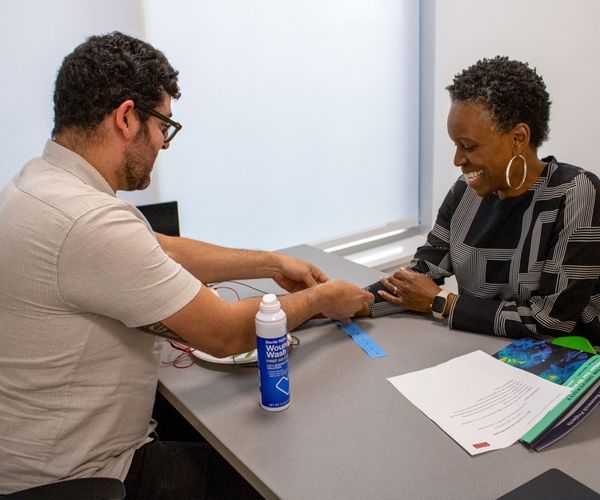 PhD student Manny Marte demonstrates a research procedure for BU President, Dr. Gilliam.
