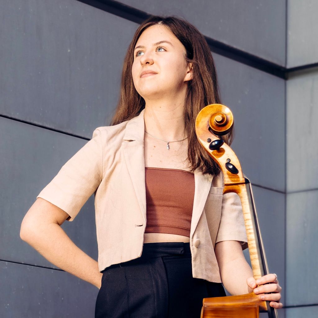Political science and philosophy major Emilia Lacy posing with a cello in her left hand as she looks up to the sky. Emilia is also pursuing a minor in music performance at BU College of Fine Arts.