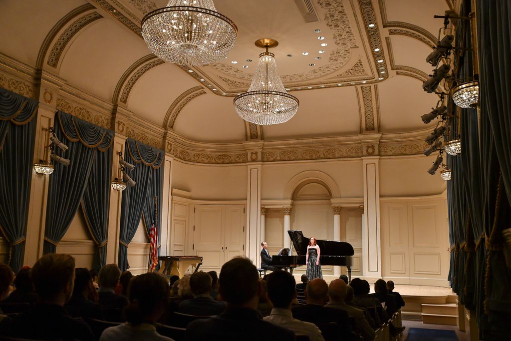 Pianist and singer performing for crowd on stage in Weill Recital Hall at Carnegie Hall for Boston University Spotlight Concert