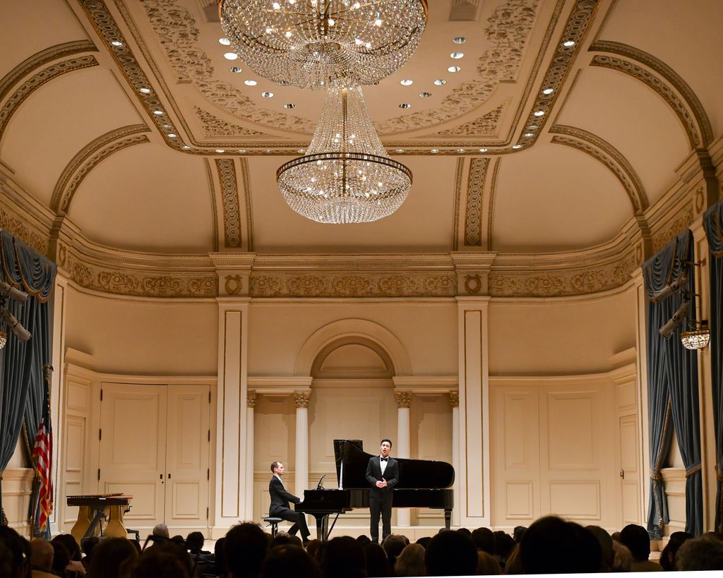 Pianist and singer performing for crowd on stage in Weill Recital Hall at Carnegie Hall for Boston University Spotlight Concert