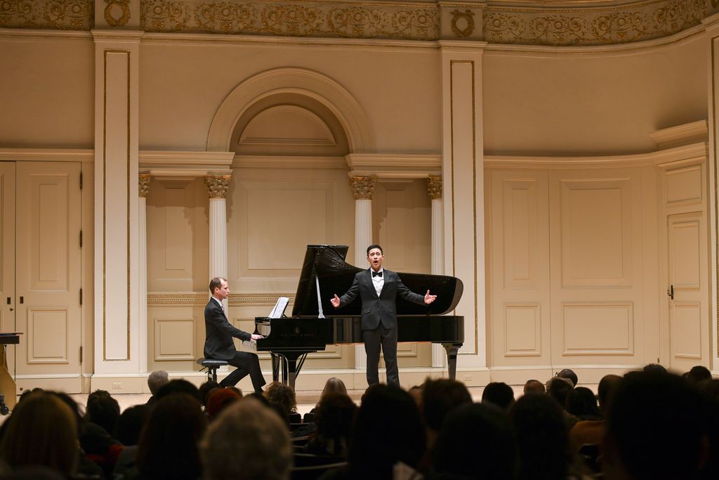 Pianist and singer performing for crowd on stage in Weill Recital Hall at Carnegie Hall for Boston University Spotlight Concert