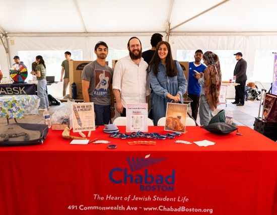 members of Chabad pose behind their table at the 宗教生活 Fair