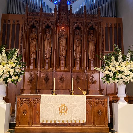 Altar in sanctuary decorated for wedding with white flowers