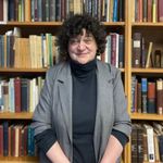 Image of Stephanie Nelson standing in font of a bookshelf