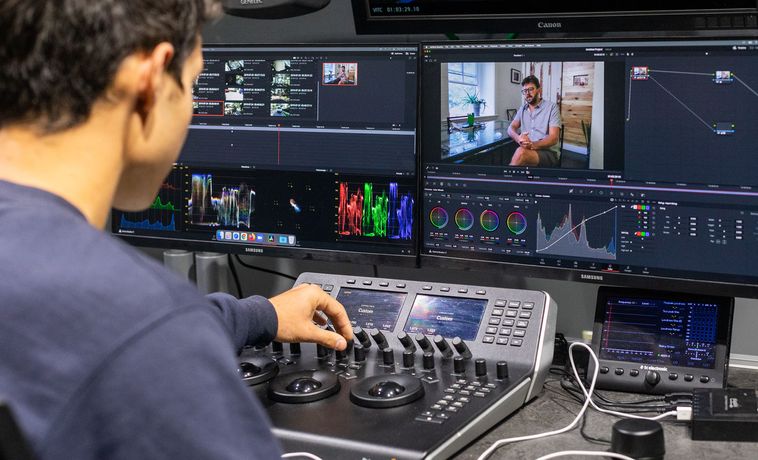 Student editing video at editing station.