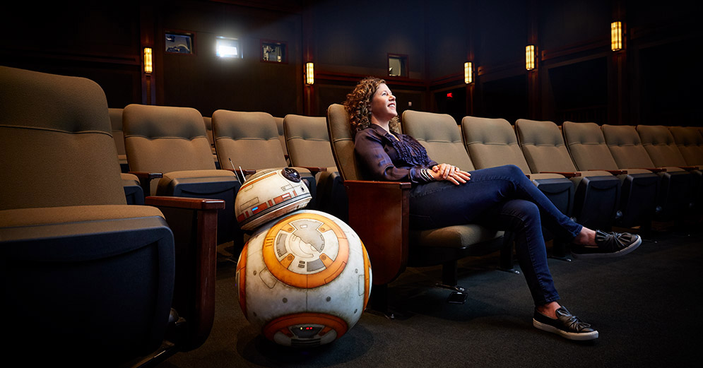 Janet Lewin sits in a theater with 星球大战 droid BB-8.