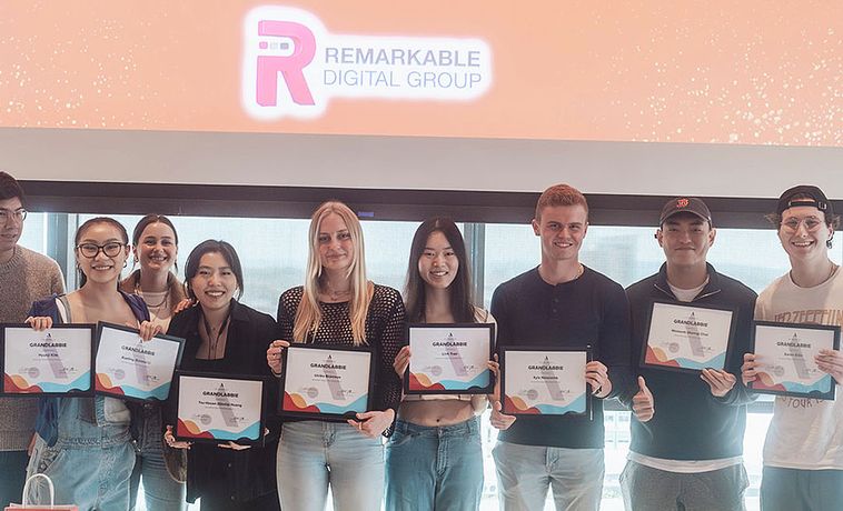 Group of students holding framed certificates.