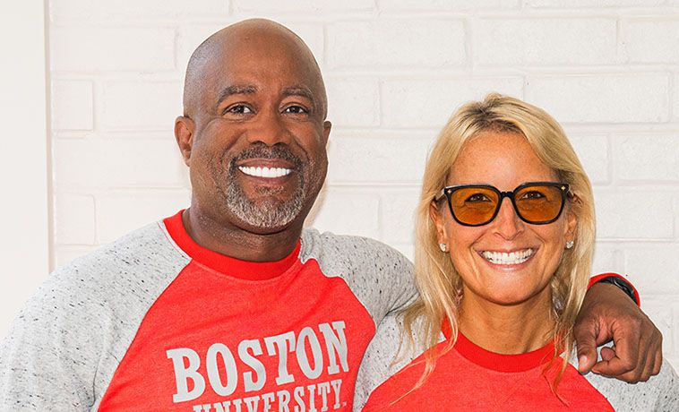 Darius Rucker poses with Bettie Levy. Both are wearing t-shirts that read 'Boston University.'