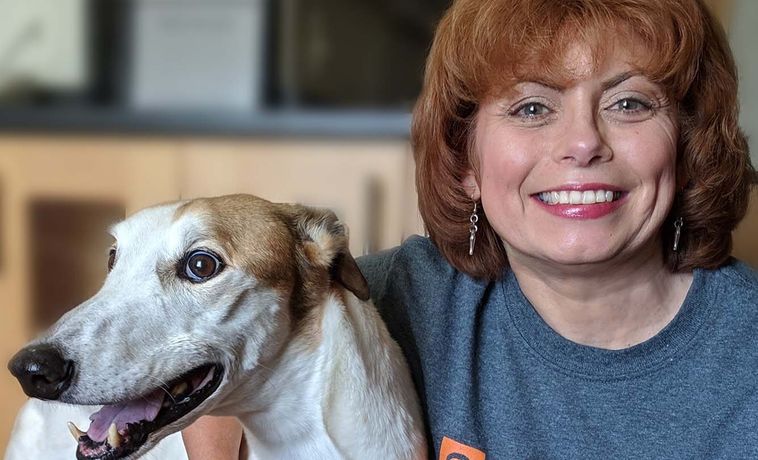 Christine Dorchak smiles with greyhound dog.