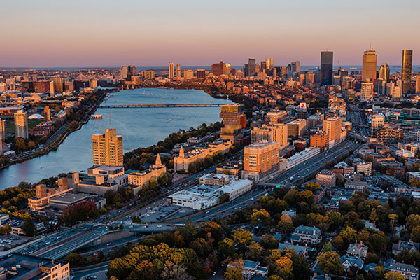 Aerial view of Boston University at dusk with Boston skyline in the background.