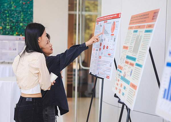 Two women browsing during a research poster session.
