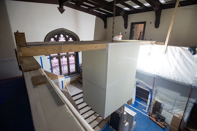 Temporary drywall and dust barriers hide the building’s signature fireplaces, chandelier, and various ornate details.