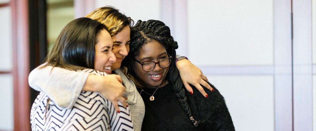 Three women hugging one another
