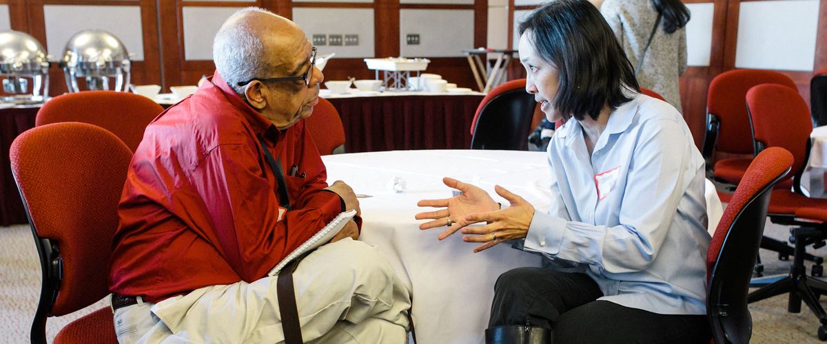 Male faculty member listening to a female associate at a Diversity event