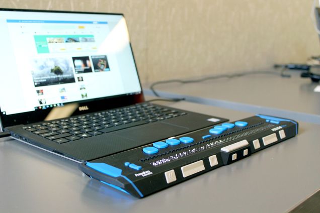 A Dell computer with an accessibility tool attached