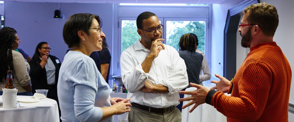 Three people standing in conversation
