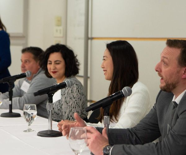 Alumni panelists smiling at networking event