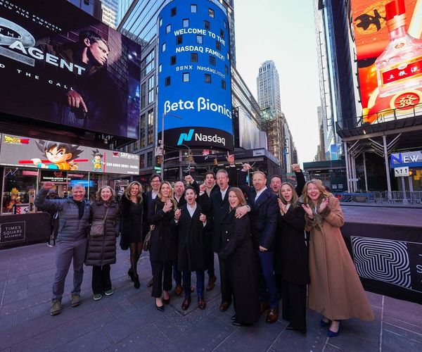 people in front of NASDAQ stock market