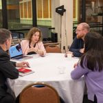 Karen Jacobs is speaking with attendees at a round table.
