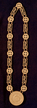 Photo: The President’s collar—which symbolizes the office of the University president—is a chain built of decorative links of entwined Bs and Us alternating with small Boston University seals, with the seal of the University suspended from it.