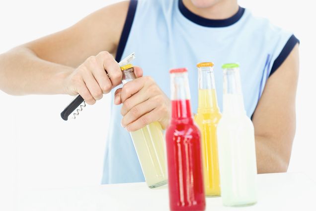 Young drinker opening bottles of beverages