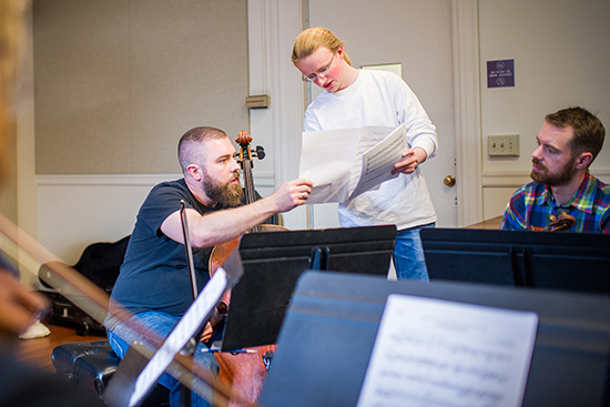 Daniel Collins hands out sheet music to JACK Quartet members, cellist Kevin McFarland and violist John Pickford Richards during an unrehearsed sight reading of his string piece