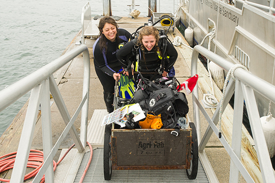 Mollie Yacano (CAS’17) (left) and Madison Montgomery (CAS’17) with a cartful of the gear they use to dive
