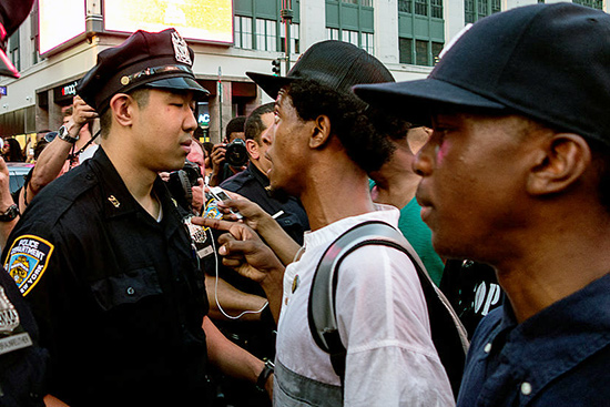 two black males are face to face with a police officer