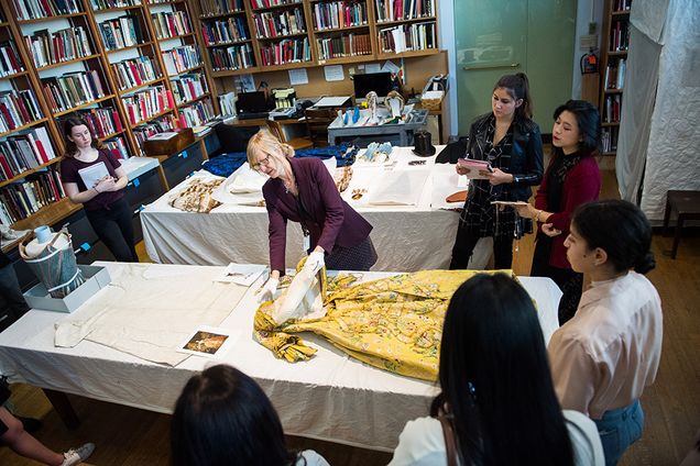 Lauren Whitley, senior curator of textile and fashion arts for the MFA, shows students a mid-18th-century English brocaded silk dress, once worn by Lydia Catherine, Duchess of Chandos.