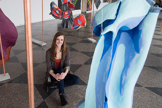 Erin Kerbert with her sculptural paintings at the 808 Gallery.