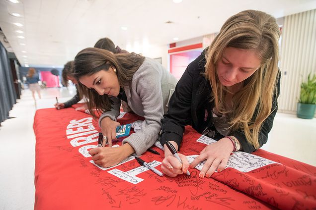 Andrea Poveda and Olivia Clause sign the GSU banner