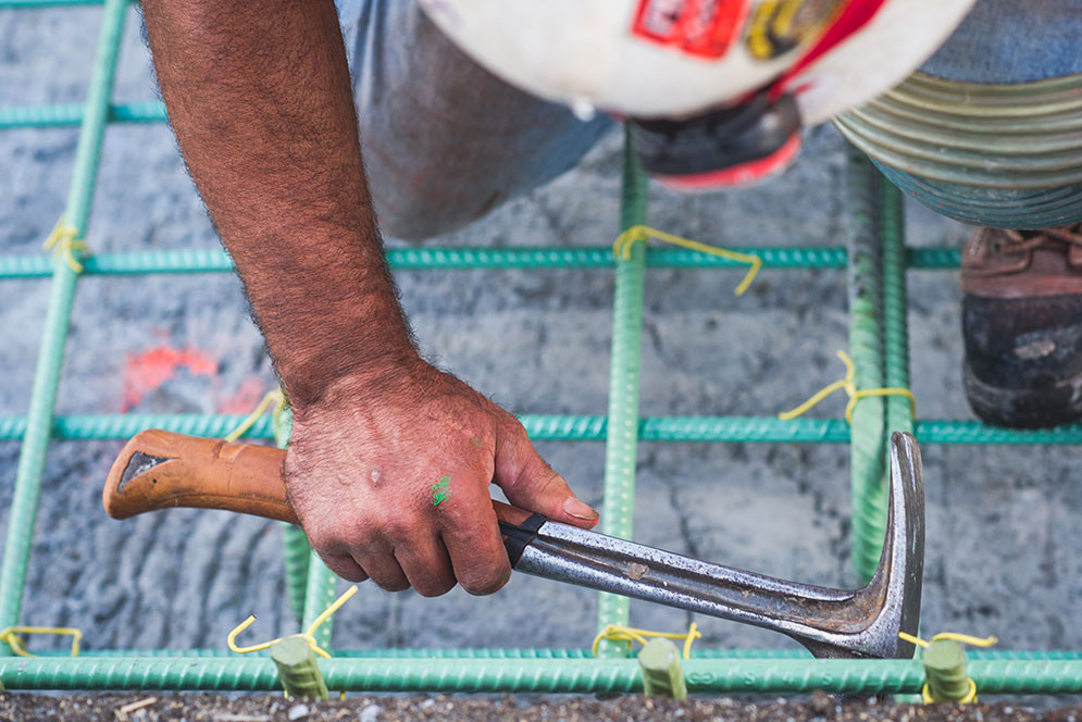 green cords and a man with a hammer