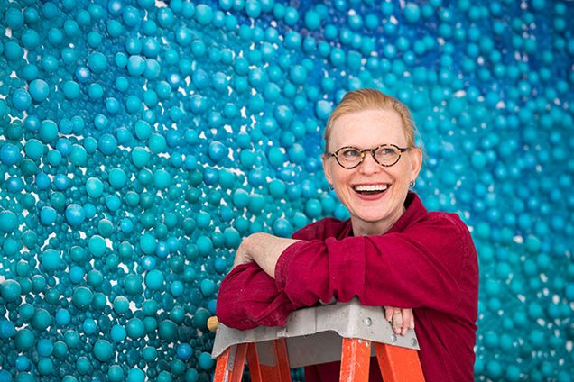 Carson Fox Smiling in front of her artwork