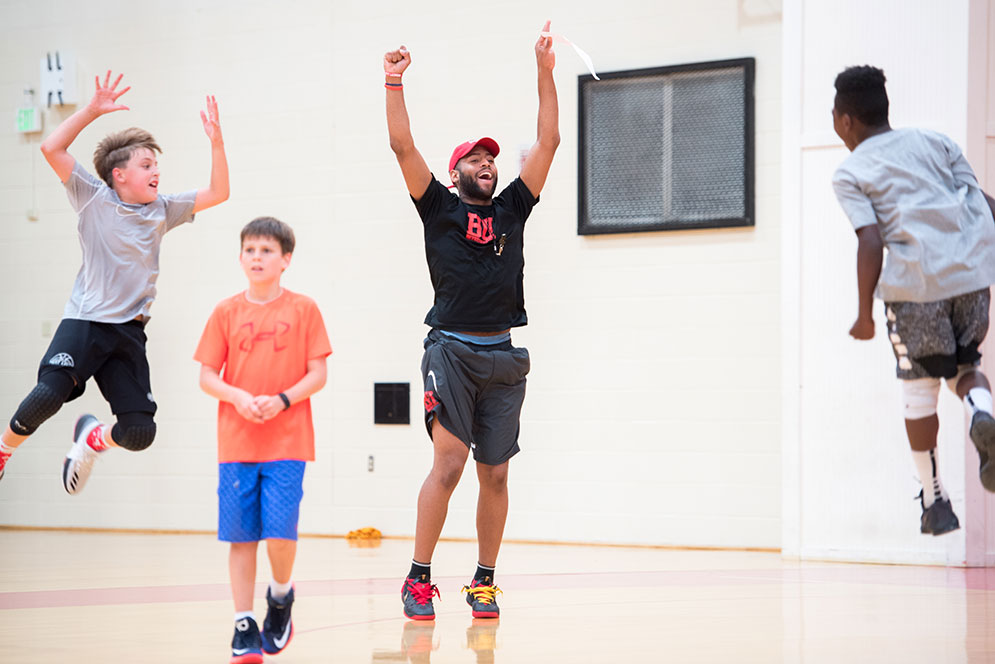 Untrammeled joy—BU men’s basketball guard Cedric Hankerson (Questrom’16, MET’18) and his Coach Joe Jones Basketball Clinic team celebrate a win at Case Gym