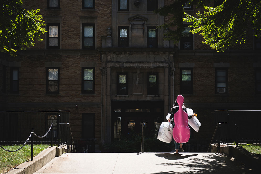A lone student wielding a pink cello case moves into a South Campus residence