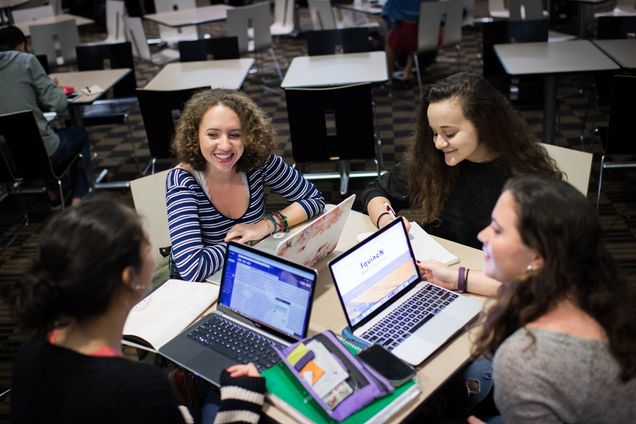 The four female founders of SquinchMag.com sit around a table.