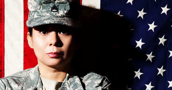 female veteran standing in front of the american flag