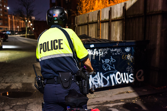 BU police officer Nancy O’Loughlin patrols the campus by bike in the early morning darkness. An internationally sought-after graffiti expert, she says every scribble offers a clue.