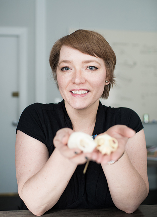 Eva Garrett, Assistant professor of anthropology at Boston University, holds primate skulls which help her study how human sense of smell evolves.