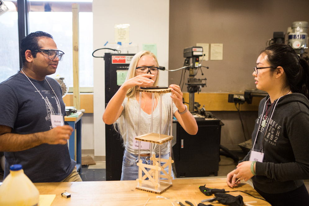 Students test how much weight their tower can withstand.