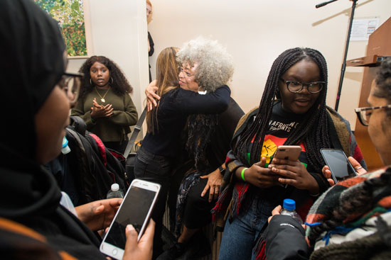 Angela Davis, activist, academic and author, at center, took time to talk with students and pose for photos after she spoke to a full crowd in Jacob Sleeper Auditorium February 9, 2019. The event, entitled Angela Davis: Violence Against Women and Its Ongoing Challenge to Racism! was made possible by The Boston University Undergraduate Sociology Association. Photo by Cydney Scott.