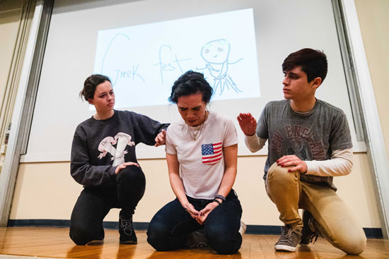 three people, the middle one is distressed and the others try to comfort them.
