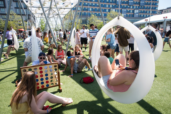 Students hanging out on swings and playing oversized games at The Lawn on D