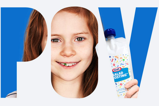 In the letters POV: a kid holds up a tube that has confetti and says Salad "Frosting" on it, while the kid has a piece of lettuce stuck in her teeth