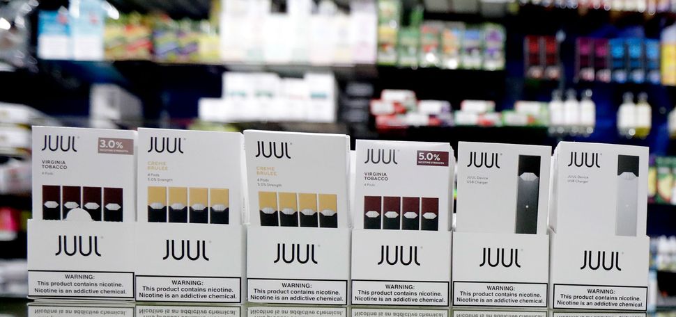 Packages of Juul e-cigarette products are seen on display at a smoke shop.